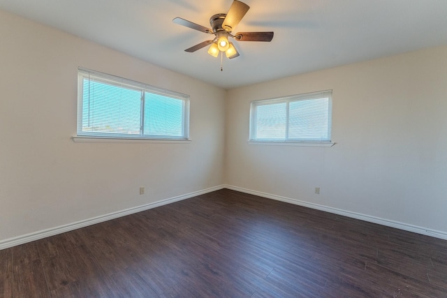 unfurnished room featuring a healthy amount of sunlight, baseboards, and dark wood-style flooring