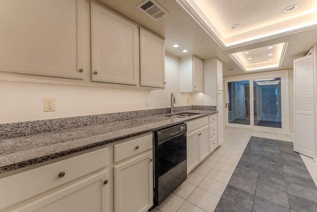 kitchen with a tray ceiling, visible vents, a sink, dark stone counters, and dishwasher