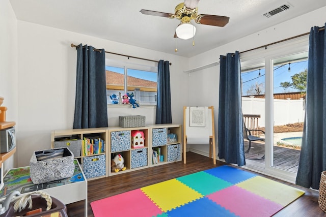 rec room with a ceiling fan, visible vents, a wealth of natural light, and wood finished floors