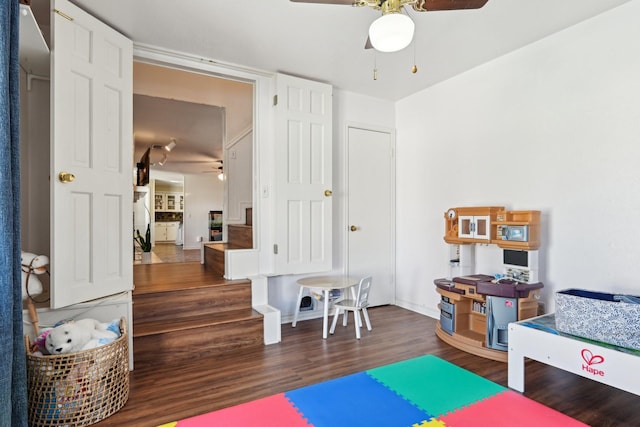 playroom with ceiling fan, baseboards, and wood finished floors