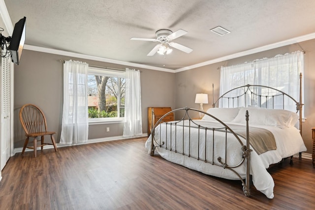 bedroom with visible vents, a textured ceiling, and wood finished floors