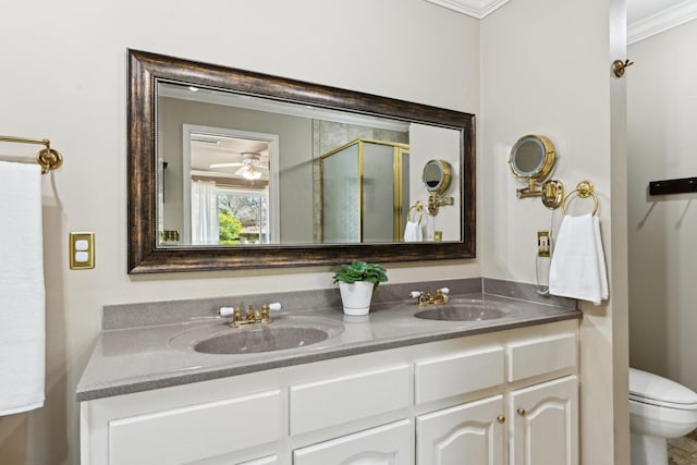 bathroom with double vanity, a shower stall, ornamental molding, and a sink