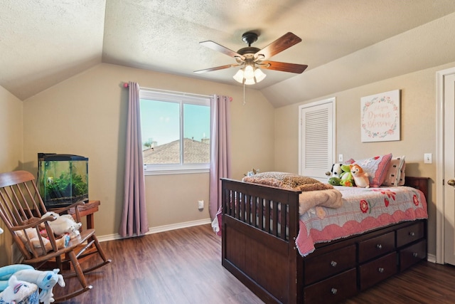 bedroom with baseboards, wood finished floors, vaulted ceiling, a textured ceiling, and a closet