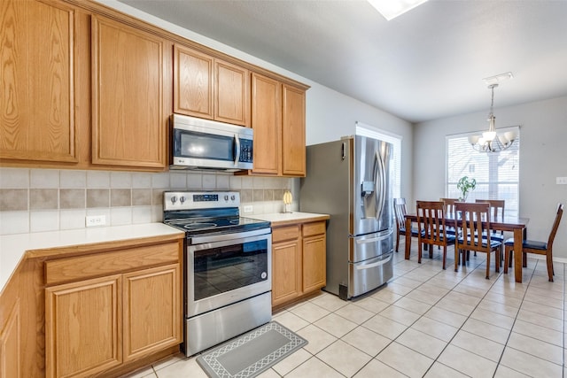 kitchen with light tile patterned floors, tasteful backsplash, appliances with stainless steel finishes, and light countertops