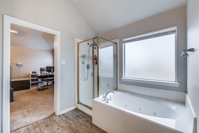 bathroom featuring a shower stall, a tub with jets, vaulted ceiling, and wood finished floors