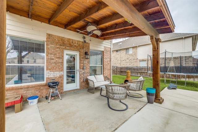 view of patio / terrace with ceiling fan, a trampoline, grilling area, and fence