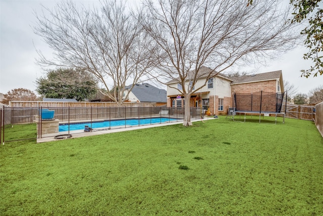 view of yard with a fenced backyard, a trampoline, and a fenced in pool