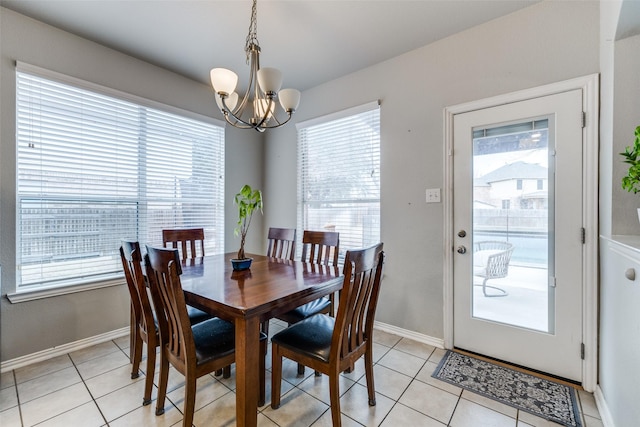 dining room with a chandelier, baseboards, and light tile patterned floors