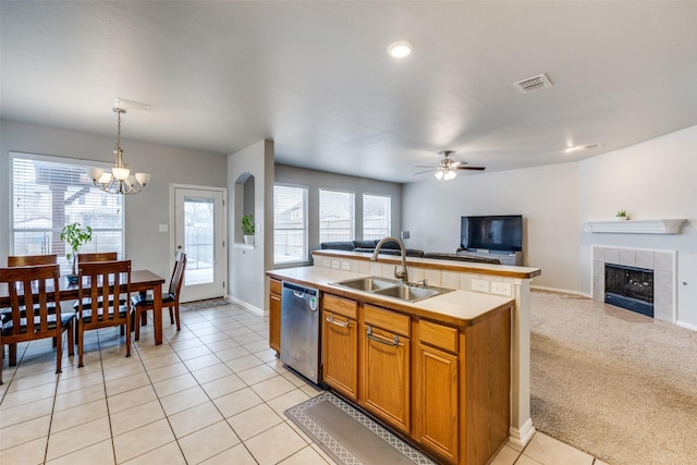 kitchen with open floor plan, light countertops, a sink, and stainless steel dishwasher