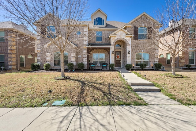 view of front of property with a front yard and brick siding