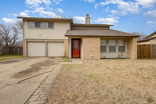 view of front of property featuring a front lawn, fence, a chimney, driveway, and an attached garage