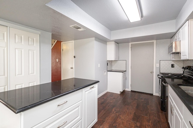 kitchen with electric range, visible vents, white cabinets, stainless steel microwave, and dark wood-style flooring