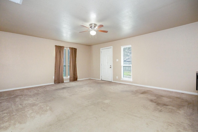 empty room with carpet floors, baseboards, and a ceiling fan