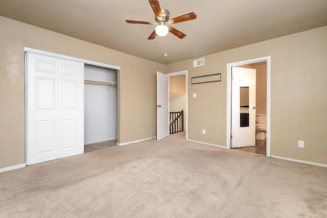 unfurnished bedroom featuring carpet, a closet, visible vents, ensuite bathroom, and baseboards