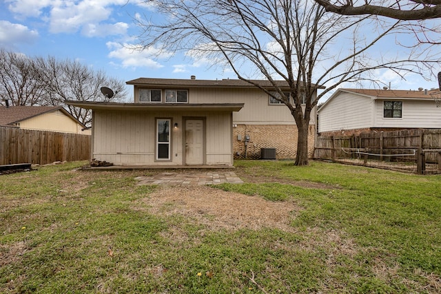 back of house with a fenced backyard, central AC, a lawn, and brick siding