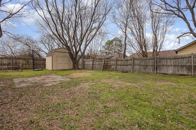 view of yard with a fenced backyard, a shed, and an outdoor structure