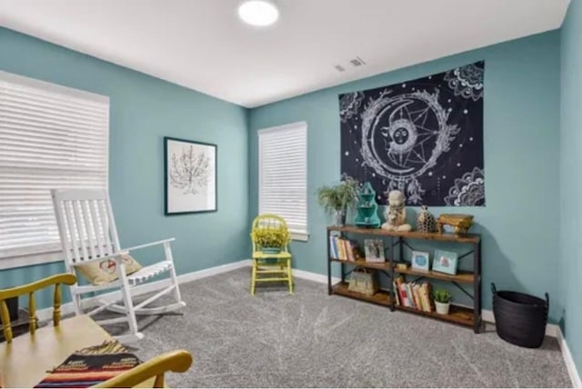 living area featuring visible vents, baseboards, and carpet flooring