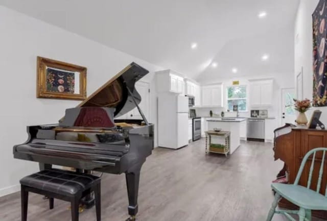 sitting room featuring lofted ceiling, light wood finished floors, baseboards, and recessed lighting