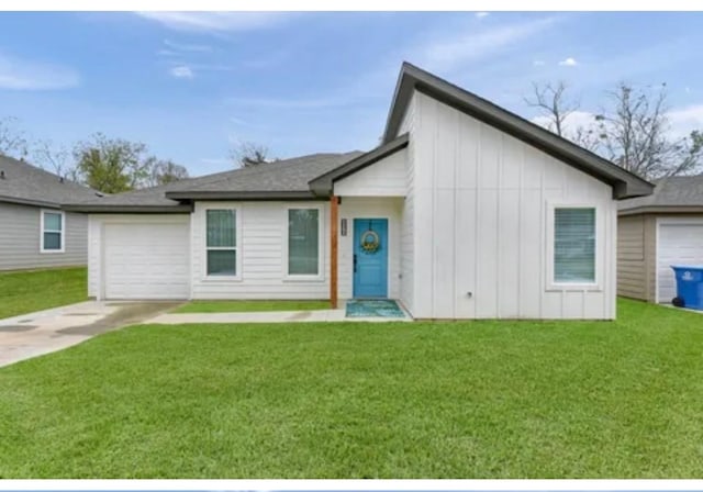 view of front of house featuring a garage, a front yard, driveway, and board and batten siding