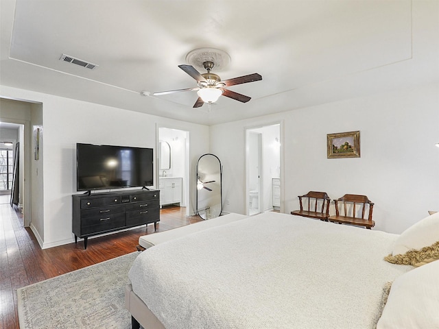 bedroom featuring baseboards, visible vents, ceiling fan, dark wood-style flooring, and ensuite bathroom