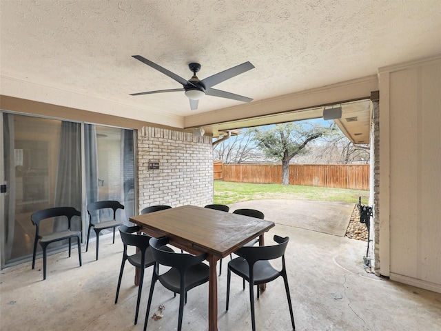 view of patio / terrace featuring a ceiling fan, outdoor dining space, and fence