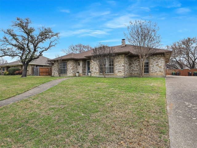 single story home with brick siding, a chimney, a shingled roof, a front yard, and fence