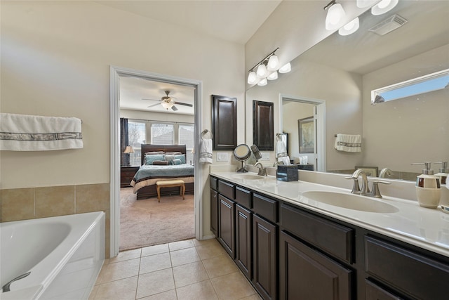 ensuite bathroom featuring tile patterned flooring, visible vents, connected bathroom, and a sink