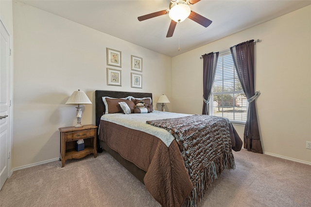 bedroom featuring light colored carpet, baseboards, and ceiling fan