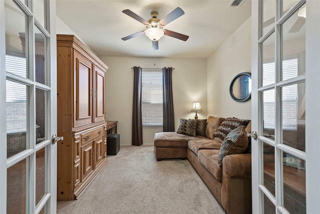 living area featuring light carpet, visible vents, french doors, and ceiling fan