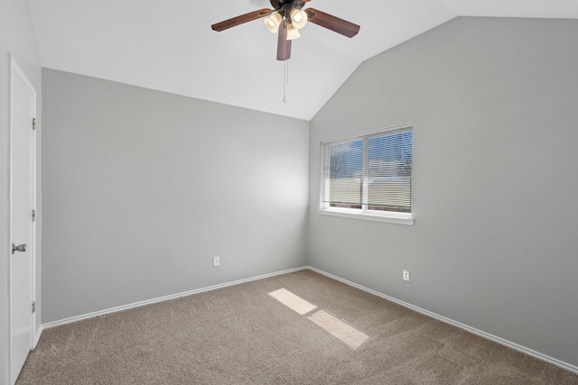 carpeted spare room with vaulted ceiling, ceiling fan, and baseboards