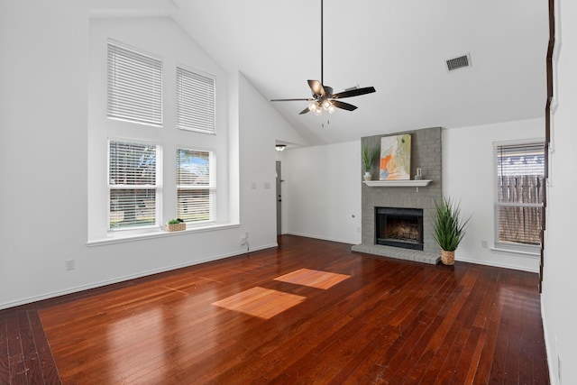 unfurnished living room with visible vents, ceiling fan, hardwood / wood-style floors, a fireplace, and high vaulted ceiling