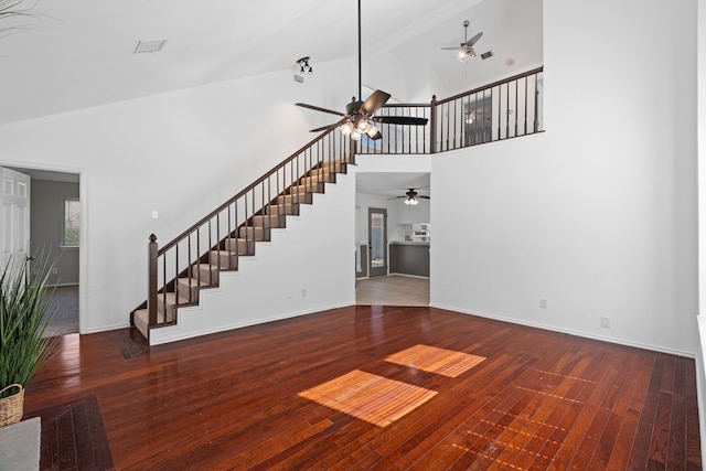 unfurnished living room featuring visible vents, stairway, baseboards, and hardwood / wood-style flooring