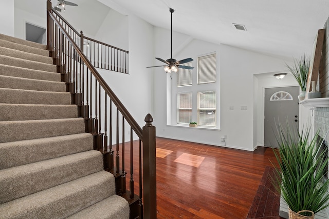 stairway with visible vents, ceiling fan, wood finished floors, a tile fireplace, and baseboards