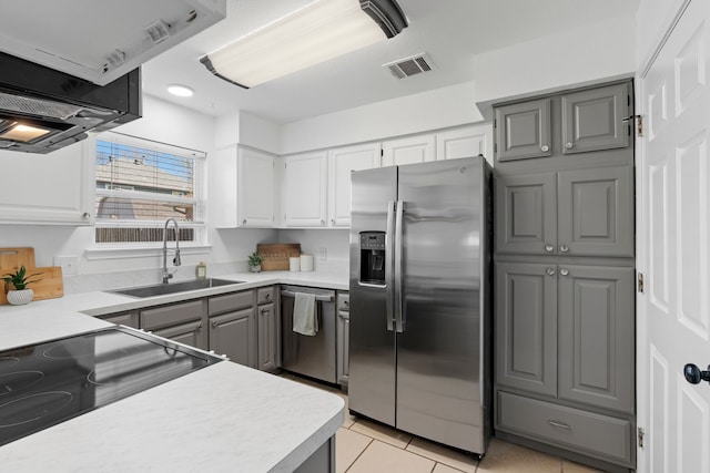 kitchen with light tile patterned floors, stainless steel appliances, a sink, visible vents, and gray cabinets