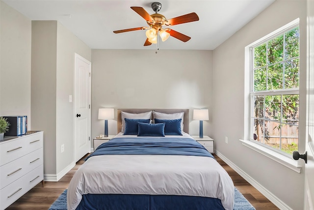 bedroom with dark wood-style flooring, ceiling fan, and baseboards