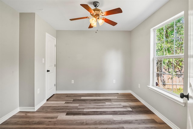 spare room with a ceiling fan, baseboards, and wood finished floors