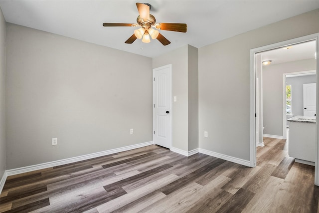 unfurnished bedroom featuring a ceiling fan, baseboards, and wood finished floors