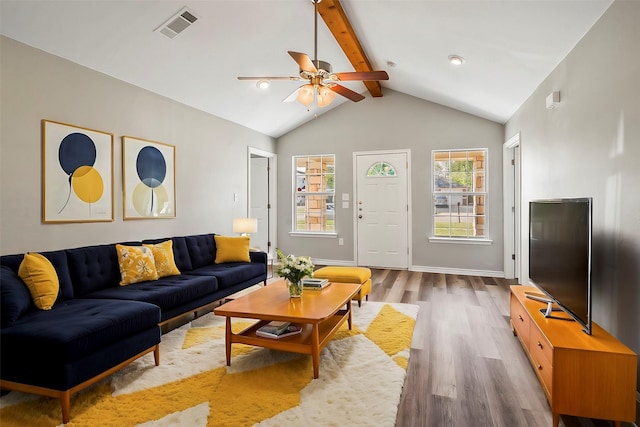 living area with baseboards, visible vents, beam ceiling, and wood finished floors