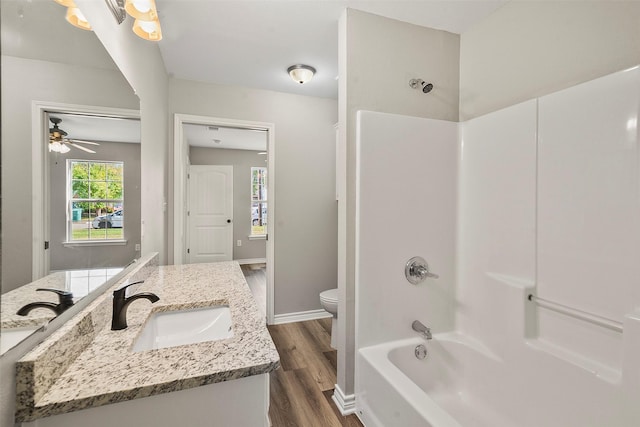 full bathroom featuring bathtub / shower combination, toilet, vanity, wood finished floors, and baseboards