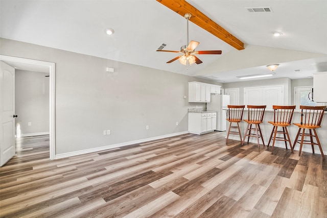 unfurnished living room with light wood finished floors, baseboards, visible vents, lofted ceiling with beams, and ceiling fan