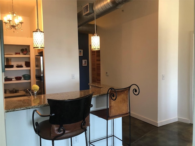 kitchen featuring visible vents, a peninsula, baseboards, and an inviting chandelier