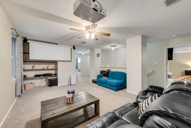 carpeted cinema featuring a textured ceiling, visible vents, and baseboards