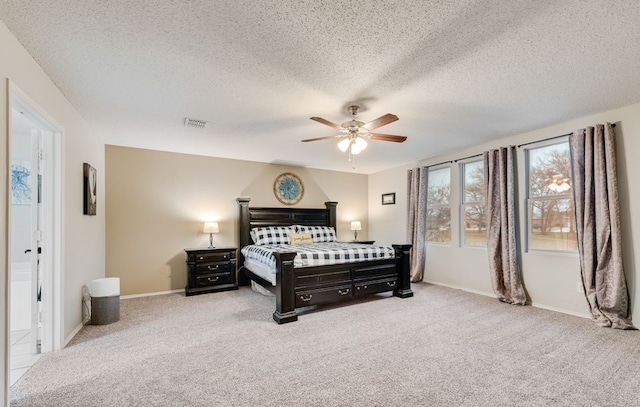 bedroom featuring baseboards, carpet, visible vents, and a textured ceiling