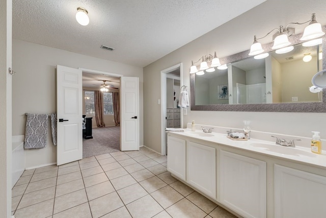 full bathroom with a textured ceiling, tile patterned flooring, a sink, visible vents, and double vanity