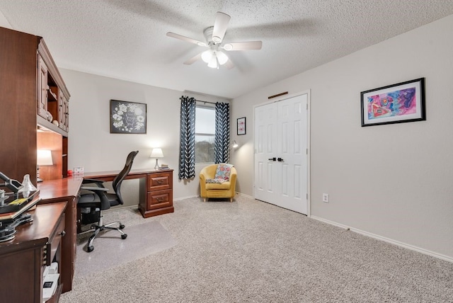 office area with carpet, baseboards, ceiling fan, and a textured ceiling