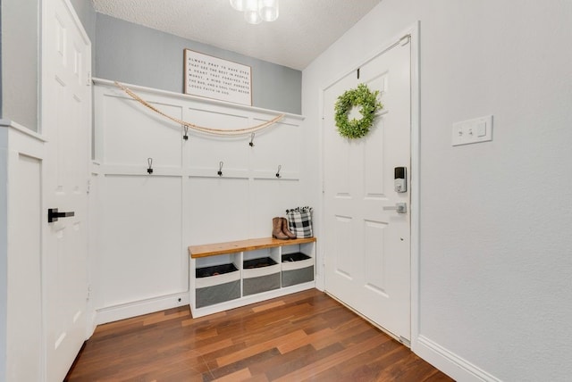 mudroom with a textured ceiling, dark wood finished floors, and baseboards