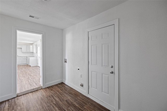 unfurnished room featuring visible vents, baseboards, and wood finished floors