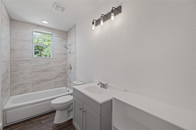 full bath with toilet, wood finished floors, vanity, visible vents, and shower / washtub combination