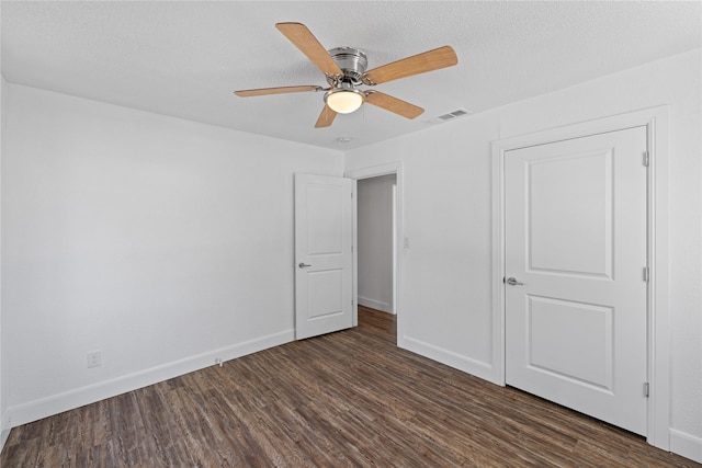 unfurnished bedroom with baseboards, visible vents, a ceiling fan, wood finished floors, and a textured ceiling