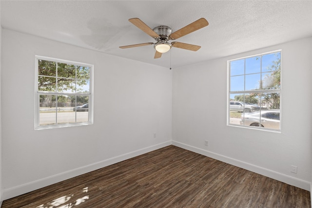 empty room with ceiling fan, baseboards, dark wood finished floors, and a textured ceiling